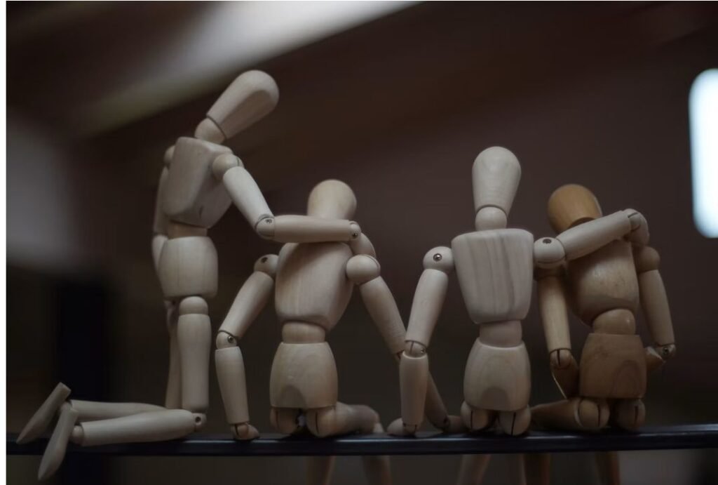Figuras humanas articuladas de madera reunidas en grupo